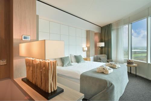 a hotel room with a bed and a large window at Van der Valk Hotel Tiel in Tiel