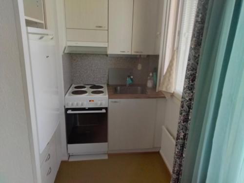 a small kitchen with a stove and a sink at Kiveläntie in Keuruu