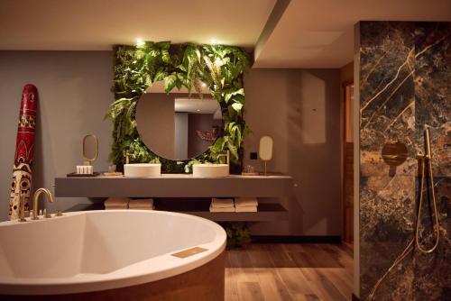 a bathroom with a tub and a large mirror at Van der Valk Hotel Tiel in Tiel