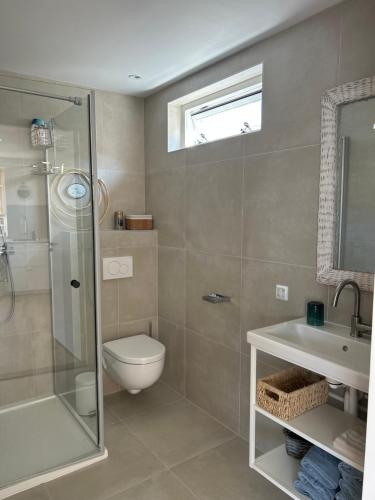 ein Bad mit einer Dusche, einem WC und einem Waschbecken in der Unterkunft Paris Plage - volledig vernieuwd, free parking in Noordwijk aan Zee