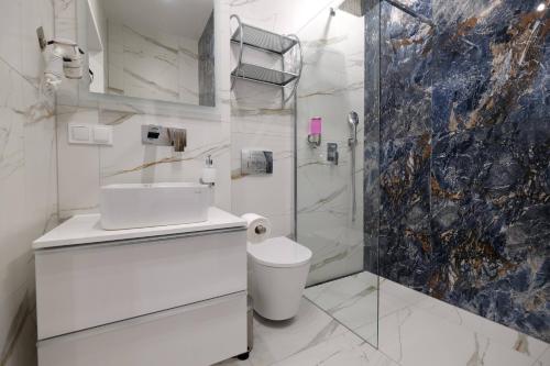 a white bathroom with a sink and a shower at Apartamenty Centrum Premium Gold in Białystok