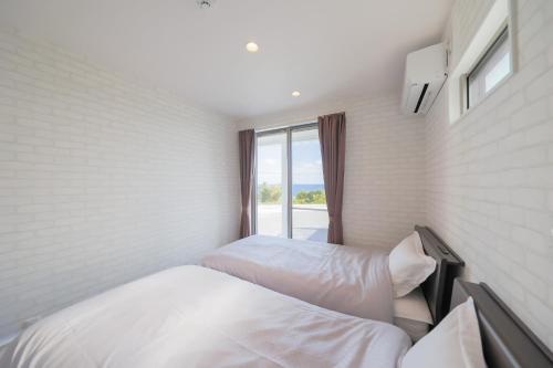 een slaapkamer met 2 bedden en een raam bij KUSUMARU - Vacation STAY 13707v in Ōkachi