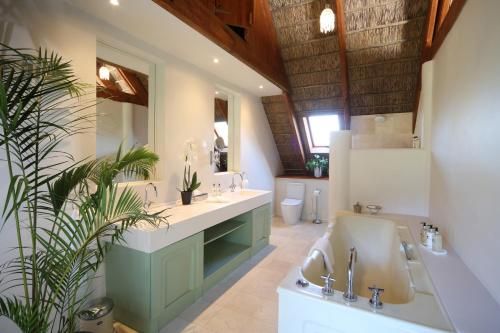 a bathroom with two sinks and two mirrors at Adara Palmiet Valley Luxurious Boutique Farm Hotel in Paarl