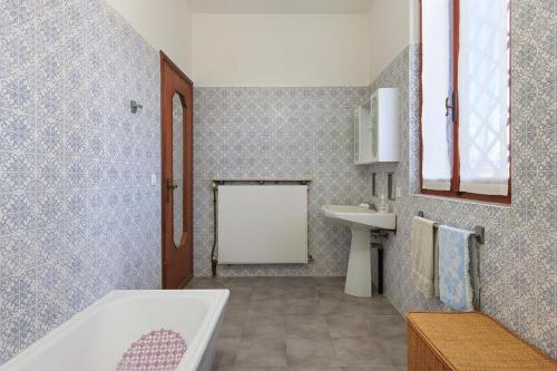 y baño con bañera y lavamanos. en Locanda Da Romano, en Cadeo