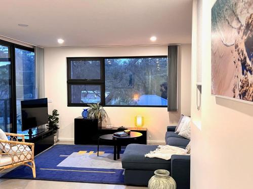un salon avec un canapé bleu et une télévision dans l'établissement Husky Sol, à Huskisson