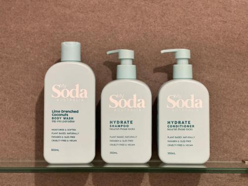 a group of three bottles of soap on a shelf at Husky Sol in Huskisson