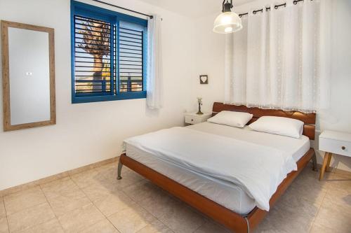 a bedroom with a bed and a mirror and a window at Nof glili Mansion in Yavneʼel