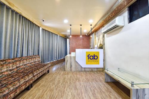 una sala de espera con sofá y una señal en FabHotel Max Inn, en Ahmedabad