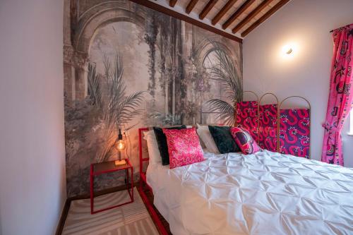 1 dormitorio con 1 cama y un mural en la pared en The secret nest in San Gimignano, en San Gimignano