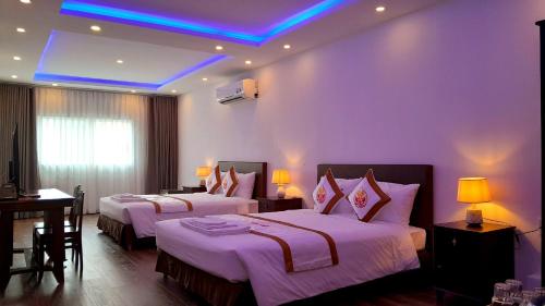 a hotel room with two beds and a blue light at THE RICE HOTEL in Ho Chi Minh City