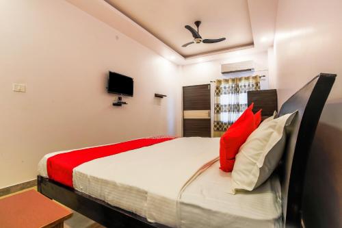 ChinhatにあるVaibhav Laxmi Paradiseのベッドルーム1室(赤と白の枕が備わるベッド1台付)