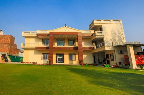 a large house with a lawn in front of it at Vaibhav Laxmi Paradise in Chinhat