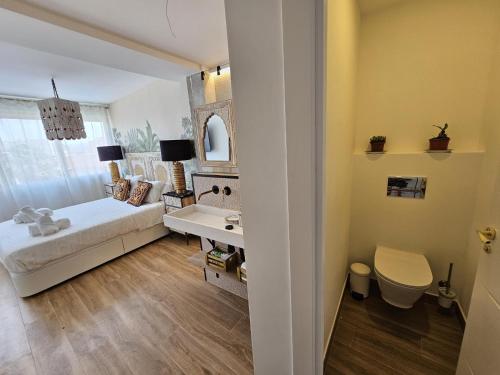 a bedroom with a bed and a desk and a mirror at La Sardina de Denia in Denia