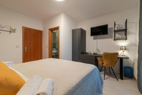 a bedroom with a bed and a desk and a chair at Villa Bakica in Trogir