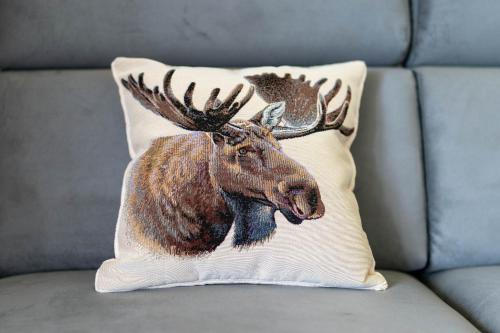 a cushion with a moose on it sitting on a couch at Łosiowe Wzgórze in Leśnica