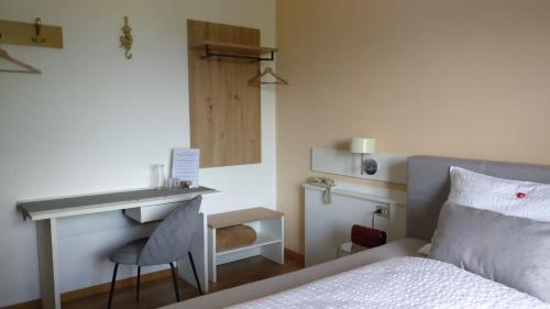 a bedroom with a bed with a desk and a bed sidx sidx sidx at Biogasthaus Plonerhof in Bressanone