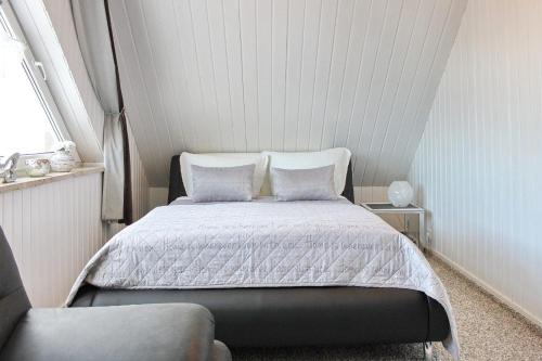 a bedroom with a bed with white sheets and pillows at Ferienhaus Windspiel in Kleeden