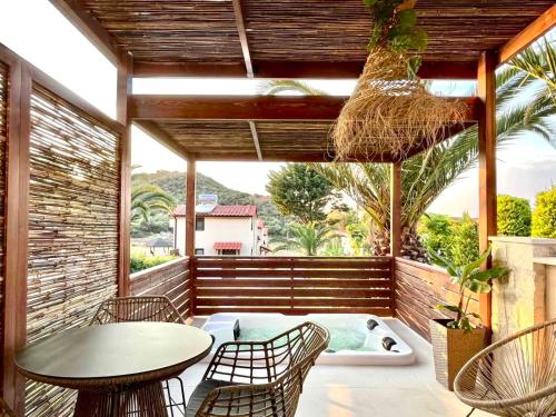 a patio with a table and chairs and a hot tub at Palma Deluxe House in Sarti