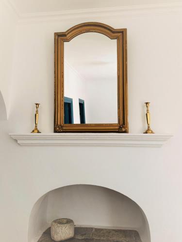 a mirror on a wall above a fireplace at Evangelia in Symi