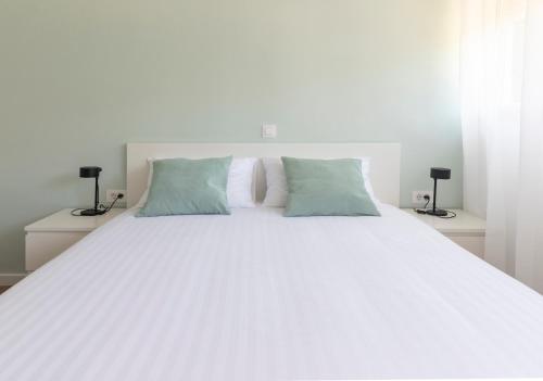 a large white bed with two pillows on it at Apartment Fani with free private parking in Dubrovnik