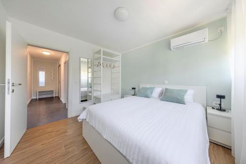 - une chambre blanche avec un grand lit et un couloir dans l'établissement Apartment Fani with free private parking, à Dubrovnik