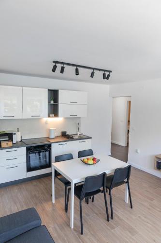 a white kitchen with a white table and chairs at Apartment Fani with free private parking in Dubrovnik
