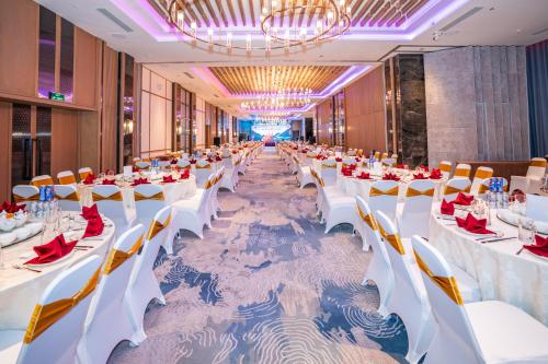 a long banquet hall with white tables and chairs at Grand Hyams Hotel - Quy Nhon Beach in Quy Nhon