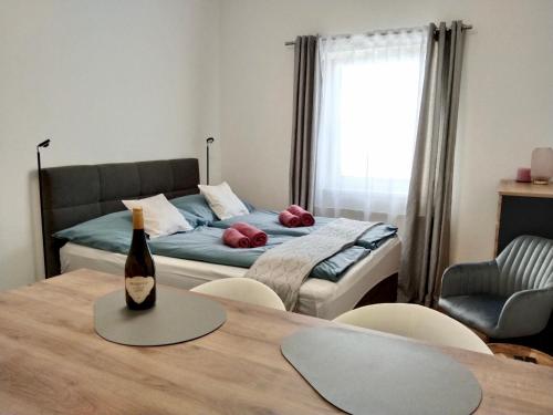 ザンクト・ペルテンにあるRuhiges Ferienapartment mitten im Zentrum Sankt Pöltenのベッド1台、ワイン1本(テーブル上)が備わります。