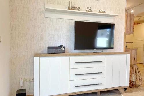 einen TV auf einer weißen Kommode mit einem Fernseher darauf in der Unterkunft Ferienwohnung Am Park in Lübbenau