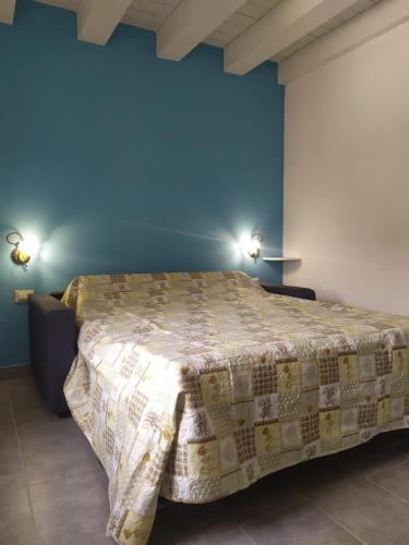 een bed in een kamer met een blauwe muur bij LAKE GARDA HOLIDAY in Salionze