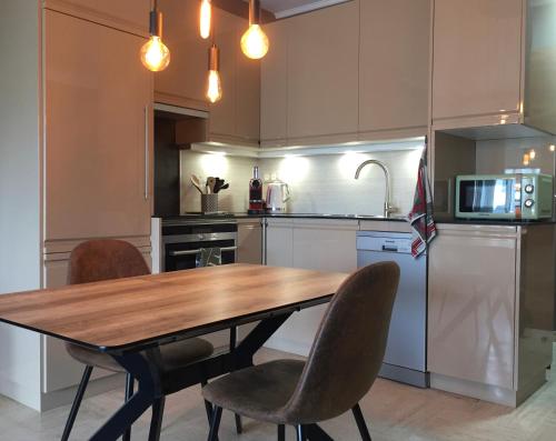 une cuisine avec une table en bois et quelques chaises dans l'établissement Appartement Mimosa Croisette, à Cannes