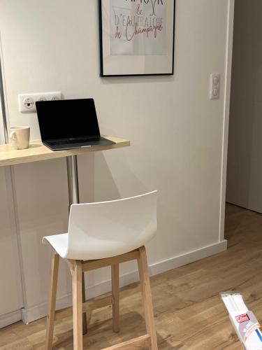 a white chair sitting next to a desk with a laptop at Champagne stars in Épernay