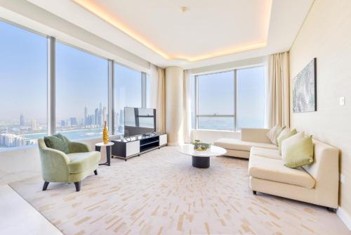 a living room with a couch and chairs and windows at Ultra Luxury Palm Tower with Shared 5 Star Hotel Facilities in Dubai