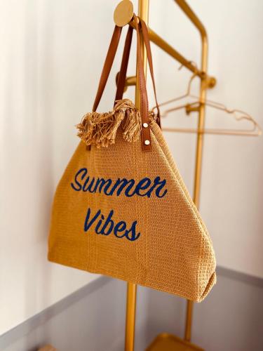 a bag with the words summer vibes is hanging at Hôtel De Londres in Menton