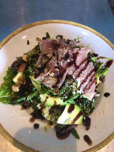 a white plate with a salad with meat and vegetables at Coralli Rooms & Restaurant in Elafonisos