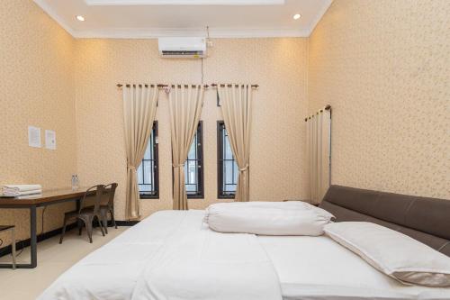 Кровать или кровати в номере Boss Residence Serang Mitra RedDoorz