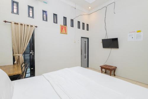 Кровать или кровати в номере Boss Residence Serang Mitra RedDoorz
