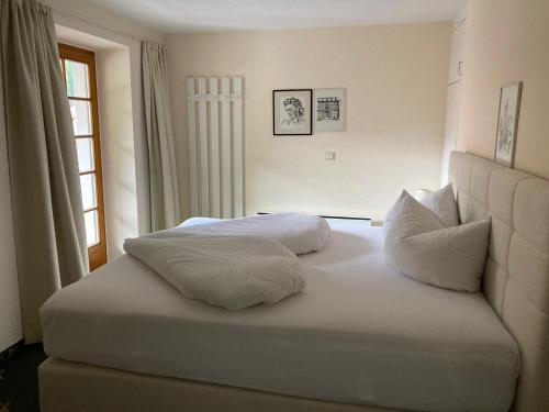 ein weißes Bett mit zwei Kissen darüber in der Unterkunft Appartement Posthäusl in Sölden