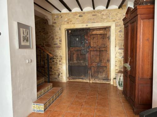 Apartamentos turísticos "El Refugio" في Algar de Palancia: غرفة مع باب خشبي كبير في مبنى