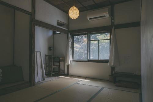 an empty room with a window and a light bulb at Nari Nuttari Nari in Niigata