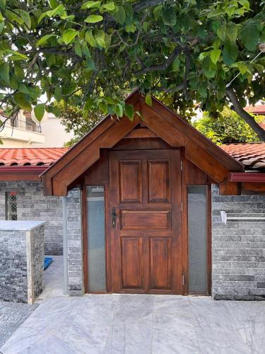 a garage with a wooden door in front of a house at Yelken Hotel Akyaka in Akyaka