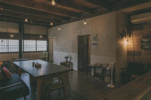 um quarto com uma grande mesa de madeira e cadeiras em Nari Nuttari Nari em Niigata