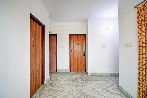 an empty hallway with two doors and a tile floor at OYO Flagship 87255 Seema Stays Inn in Thākurdwari