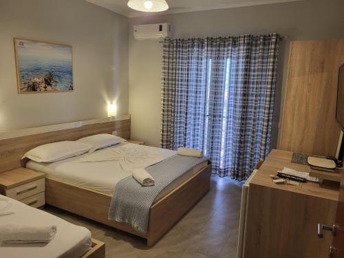 a small bedroom with a bed and a window at Augustus Hotel in Dhërmi