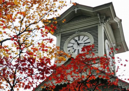 a clock tower on top of a building with autumn leaves at Tokyu Stay Sapporo Odori in Sapporo