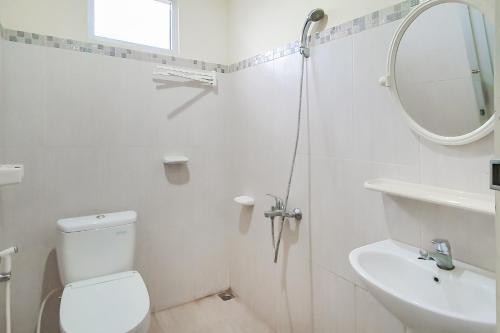 a bathroom with a toilet and a sink and a mirror at Urbanview Hotel Bartu Moh Toha Bandung by RedDoorz in Bandung