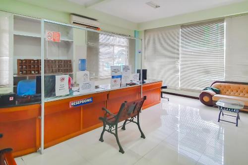 una sala de espera con escritorio y silla en Urbanview Hotel Bartu Moh Toha Bandung by RedDoorz en Bandung