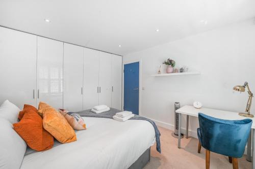 Cette chambre comprend un lit avec une chaise bleue et un bureau. dans l'établissement Spacious 2 bedroom Apartment in Camden, à Londres