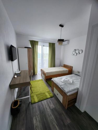 Habitación pequeña con 2 camas y escritorio. en Armina's Residence 2, en Dumbrăviţa