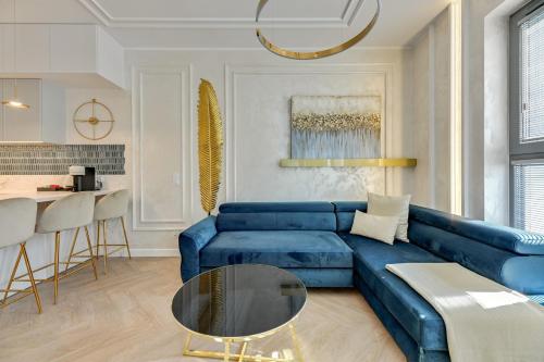 Granaria Comfort Apartments في غدانسك: غرفة معيشة مع أريكة زرقاء وطاولة